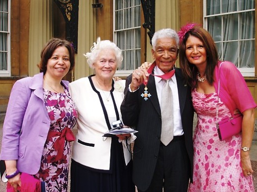 Earl Cameron after being awarded the CBE at Buckingham Palace (2009) with his wife Barbara and his daughters Serena and Jane