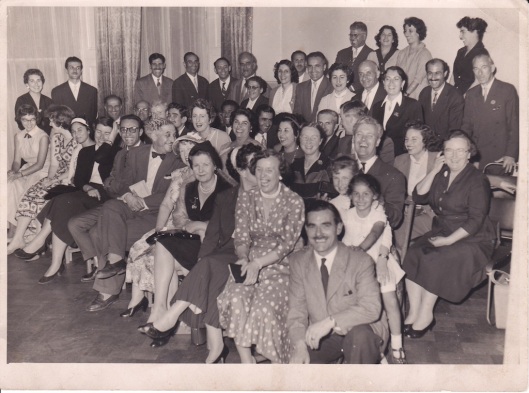 Nineteen Day Feast (London) 1958. Rose and John Wade can be seen to the right of this photo, John crouching down in the front and Rose sitting at the end of the 3rd row. Their daughter Margaret is sitting directly behind her father with a small girl on her lap and their other daughter, Christine, is standing at the end of the first row